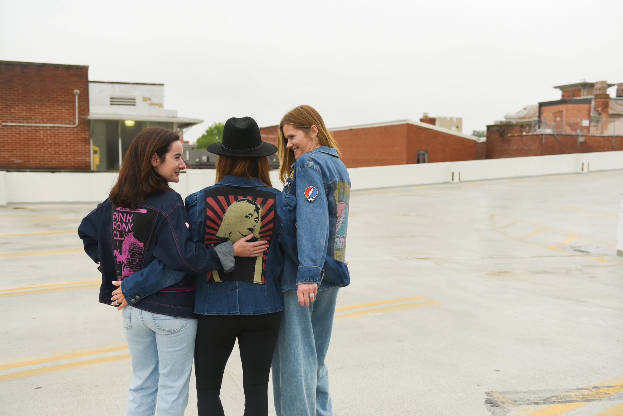 Models wearing a one-of-one upcycled denim jackets styled as a handmade Switch Purse statement look