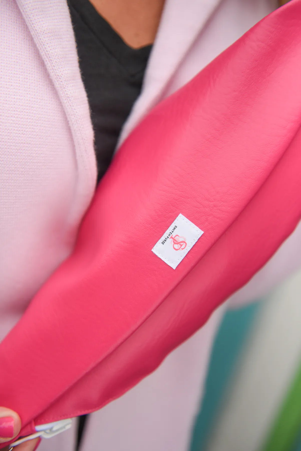 Close-up detail of a pink breast cancer awareness reversible Switch Purse sling bag